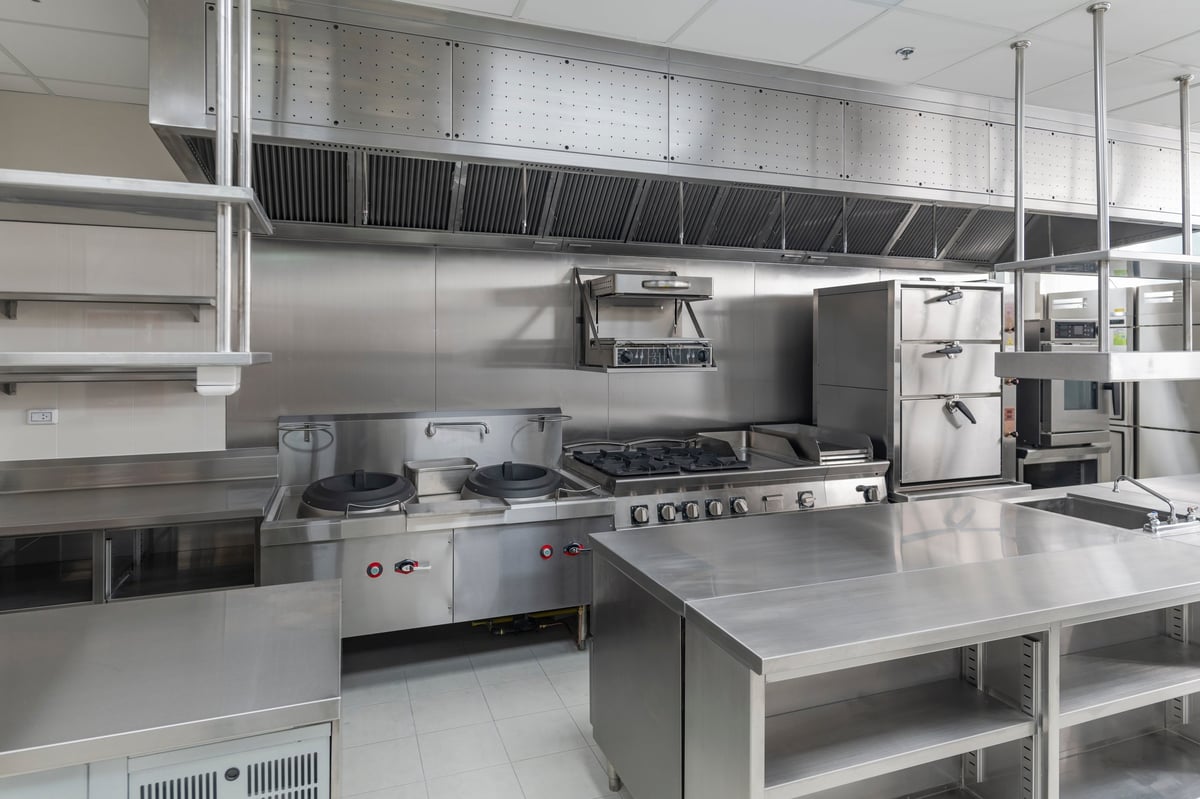 Modern commercial kitchen fitted with stainless steel equipment