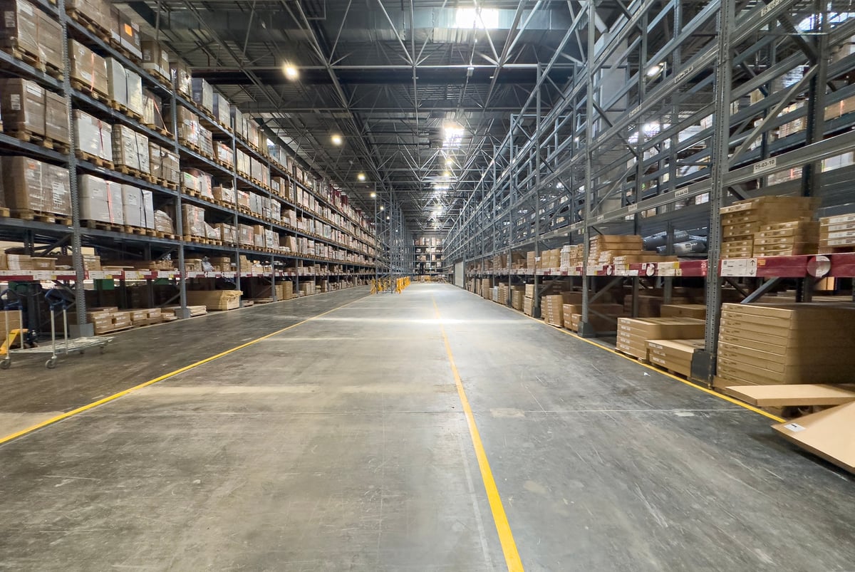 Interior of a large industrial warehouse with neatly organised shelving and stored materials