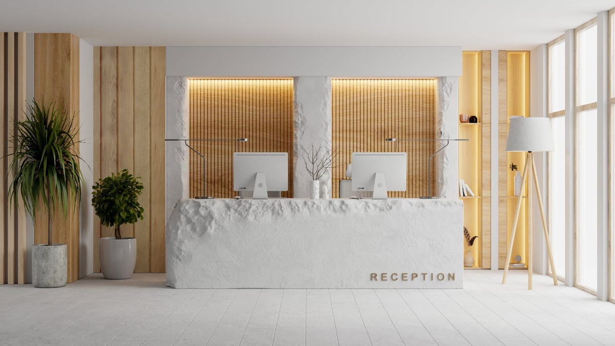 A modern hotel reception interior with a stone counter, wooden wall accents and minimalist decor