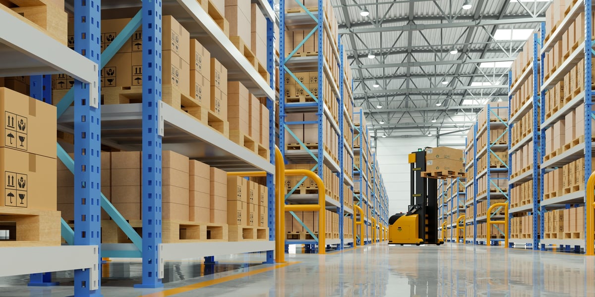 Warehouse and logistics operation with palletised goods and racking, viewed down an aisle