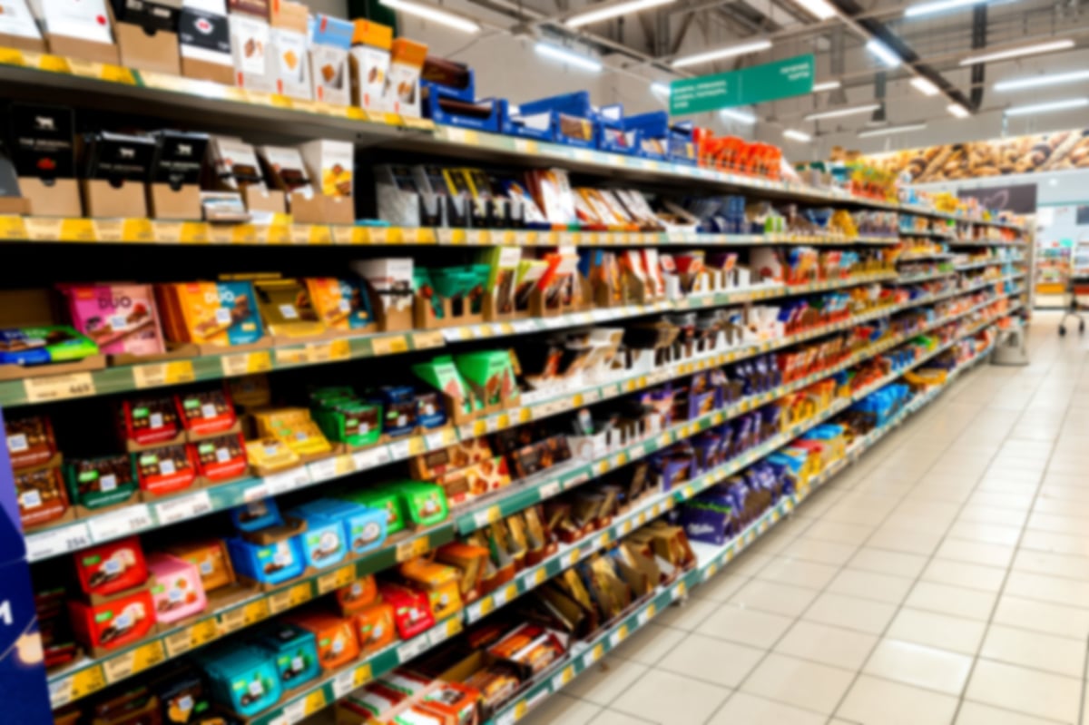 Shoppers browsing packaged goods on supermarket shelves