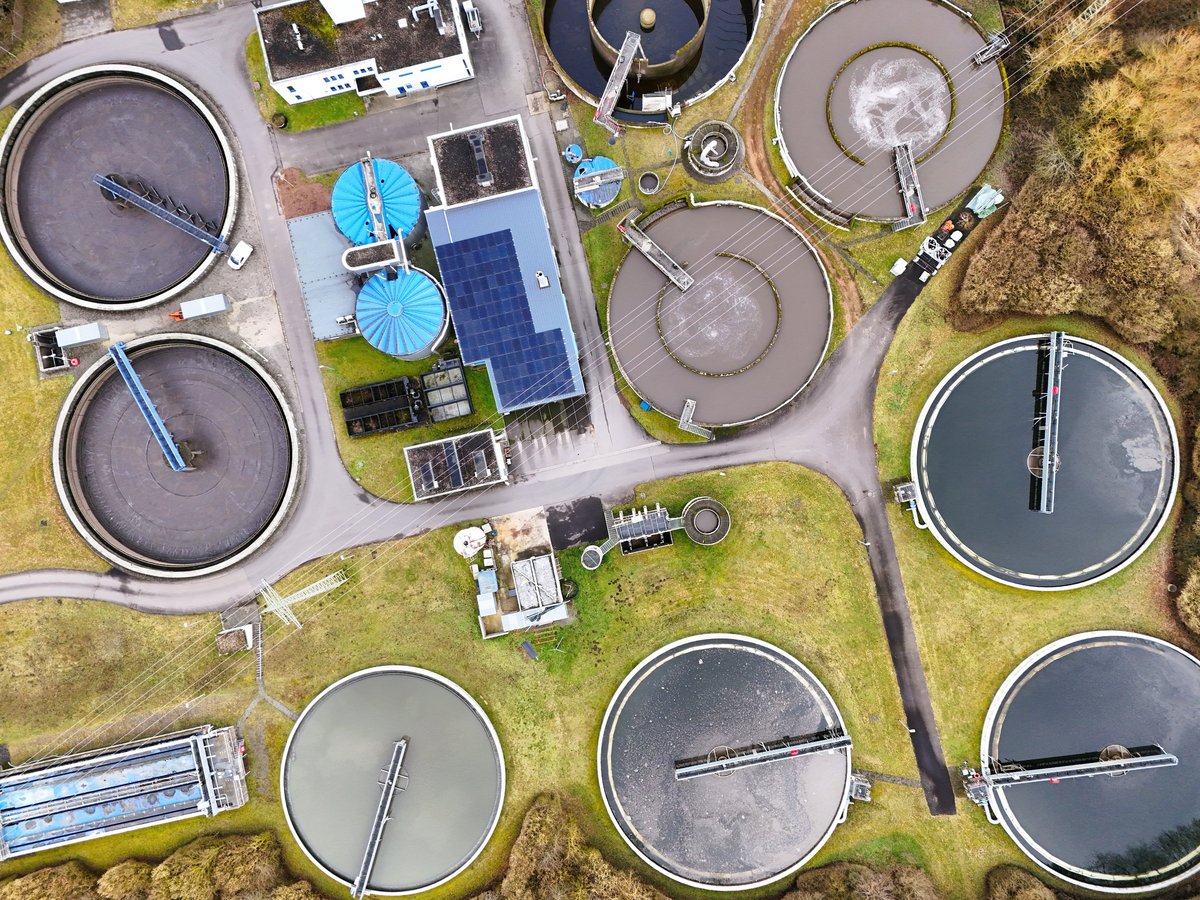 Aerial view of a wastewater treatment facility with circular settling tanks
