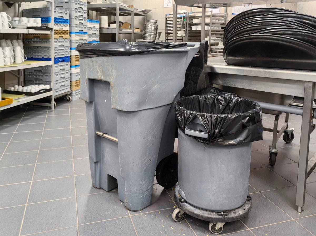 Wheeled waste bins in a commercial kitchen preparation area