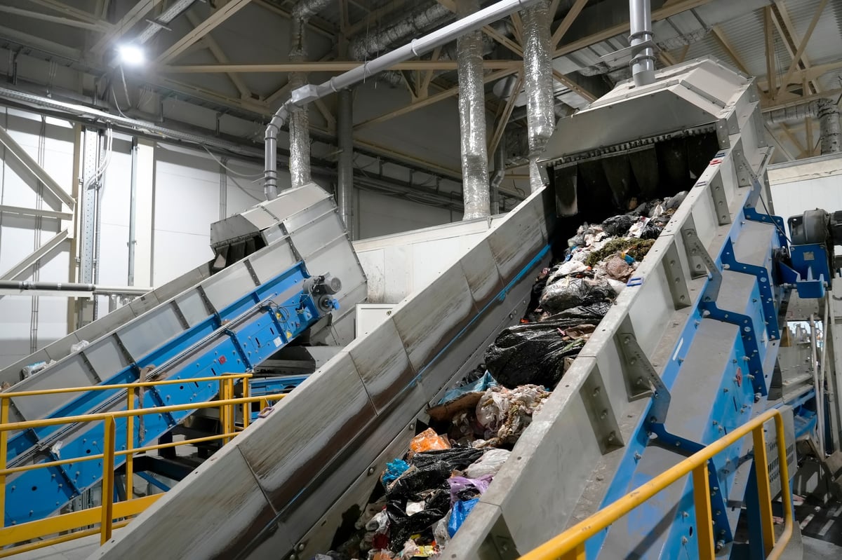 A conveyor belt with waste at a plant, waste moves along the belt to be sorted into fractions and collected for further processing
