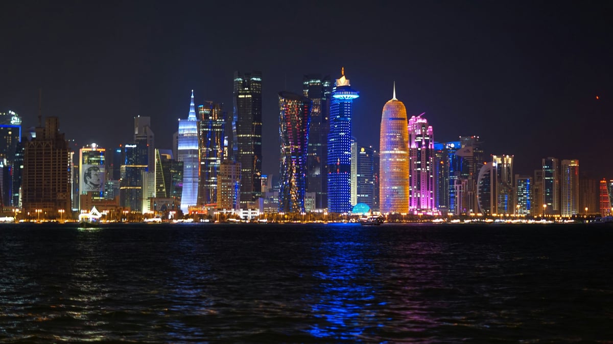Doha's illuminated West Bay skyline viewed across the water from the Corniche