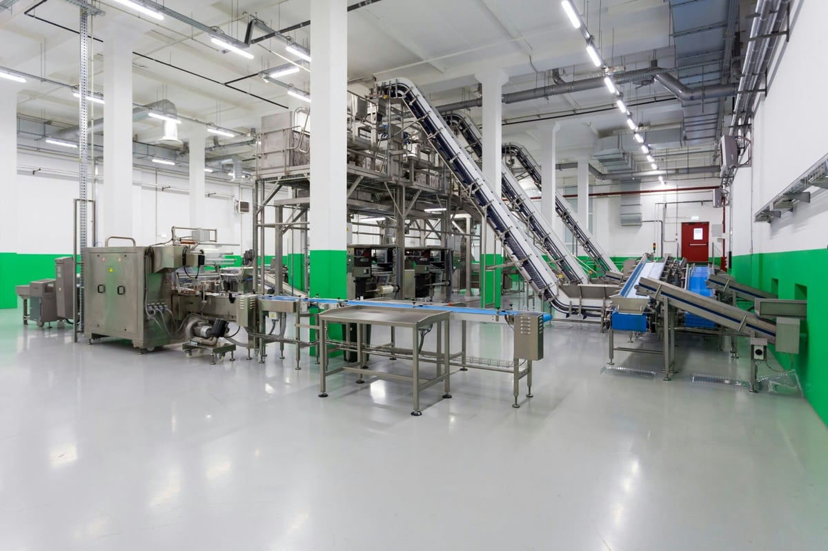 Conveyors and stainless-steel processing equipment inside a factory