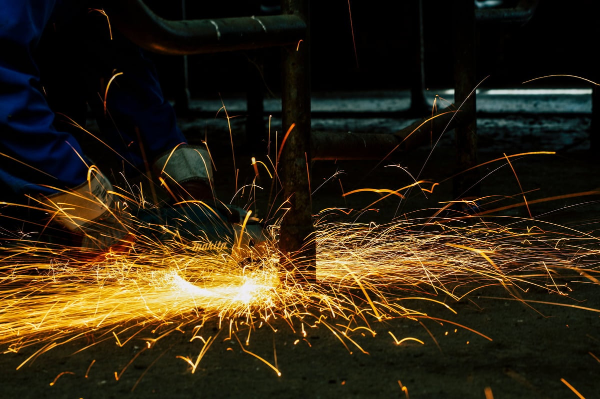 Orange sparks from an angle grinder cutting metal in a workshop