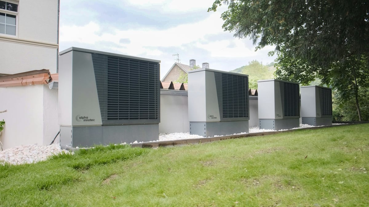 A row of outdoor heat-pump units beside a building