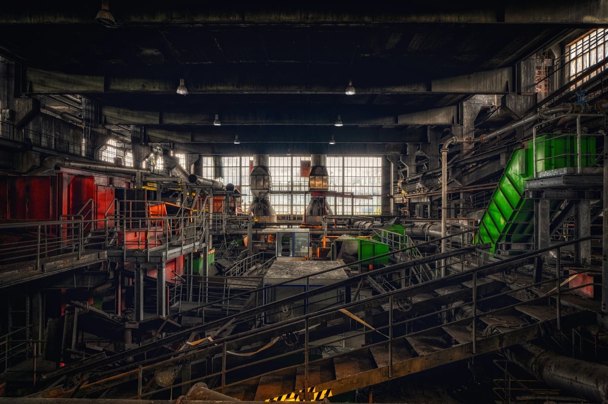 Industrial processing equipment, pipework and walkways inside a factory building