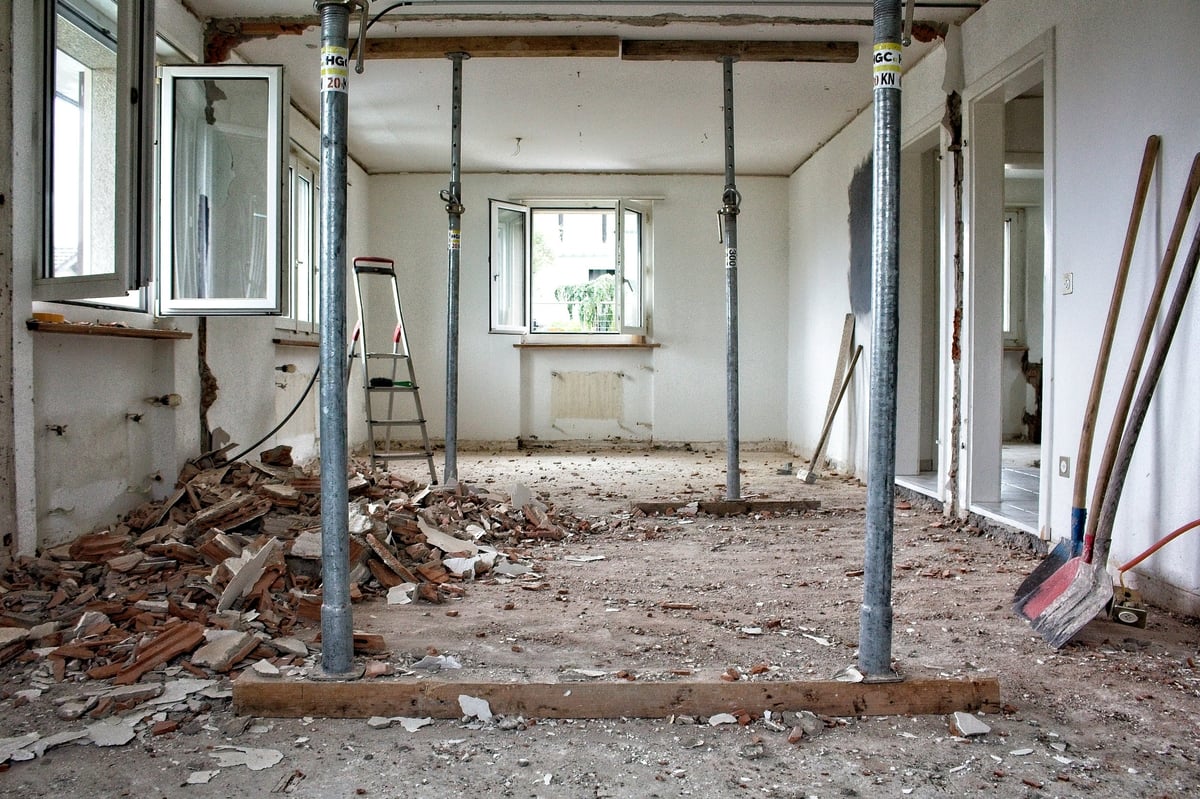 Building interior during renovation, with temporary supports, exposed masonry and removed materials