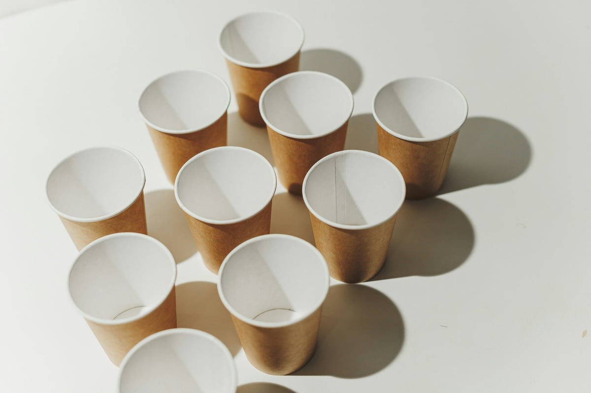 A group of brown paper cups arranged on a light surface