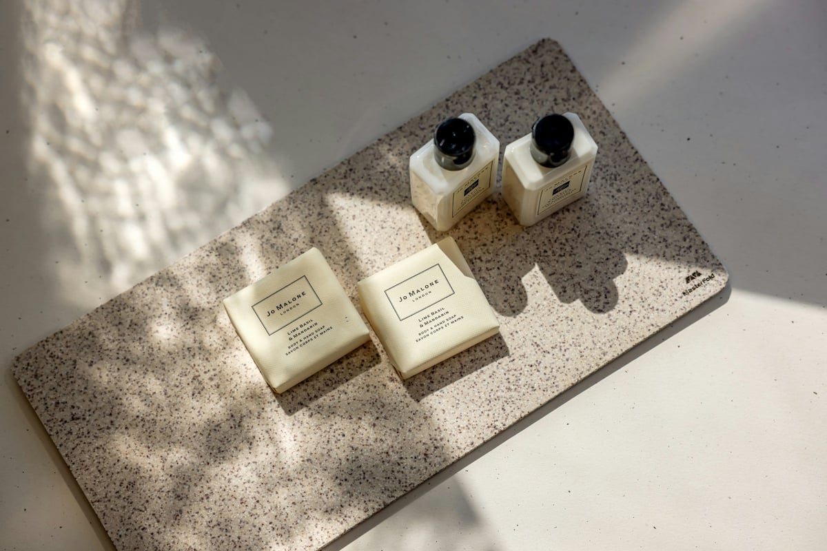 Hotel toiletries arranged on a textured tray in natural light