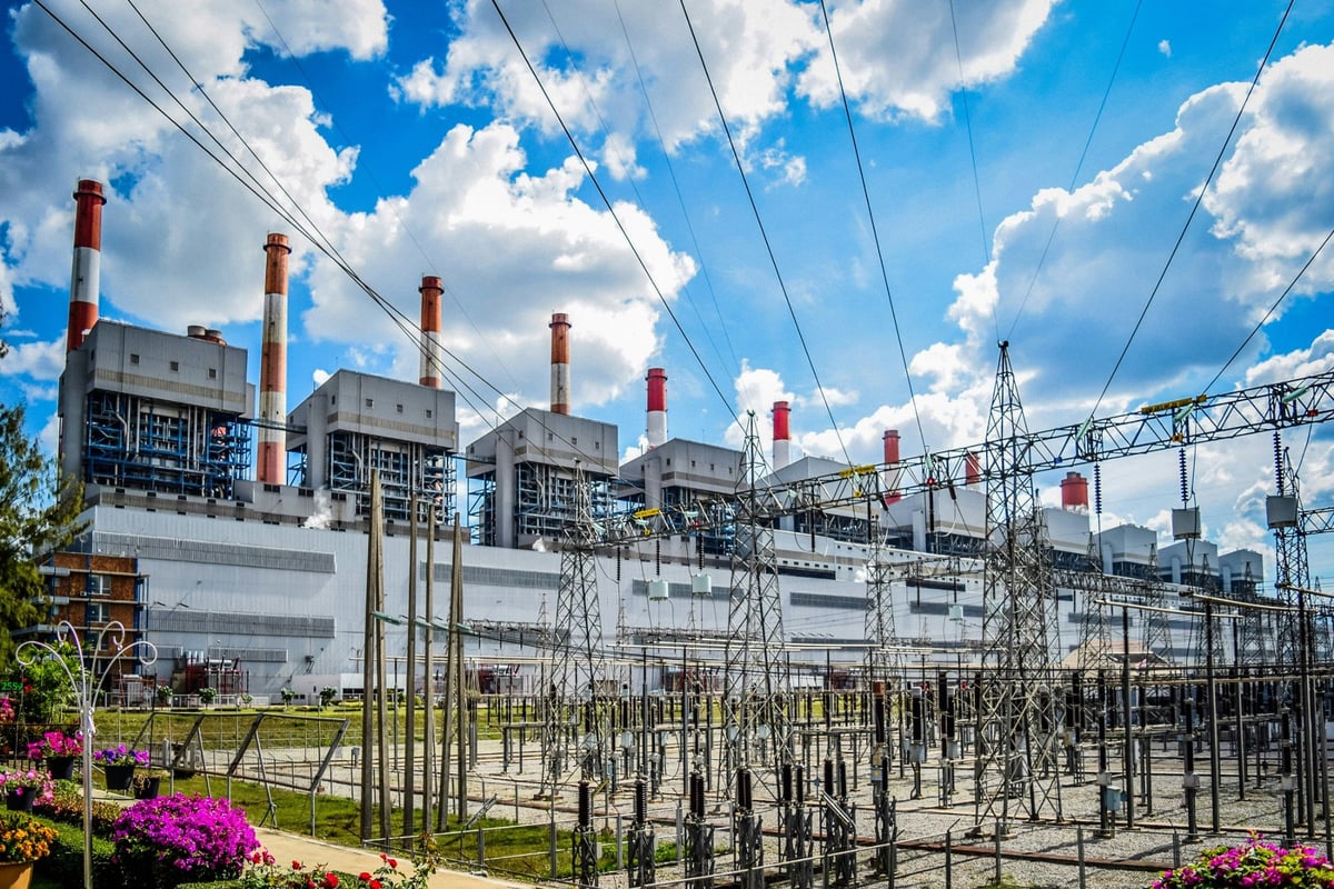 Power station buildings and chimneys behind electrical substation equipment